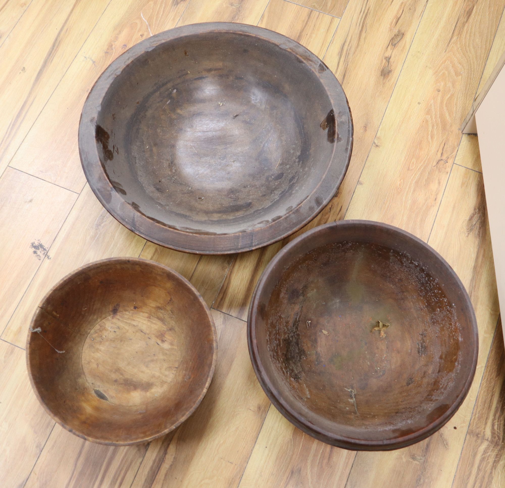 Three large treen bowls, largest diameter 47cm